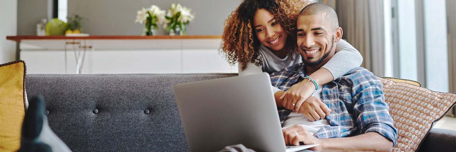 Photo: couple smiling looking at laptop