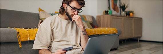 A man learns about debt collection scams on his laptop